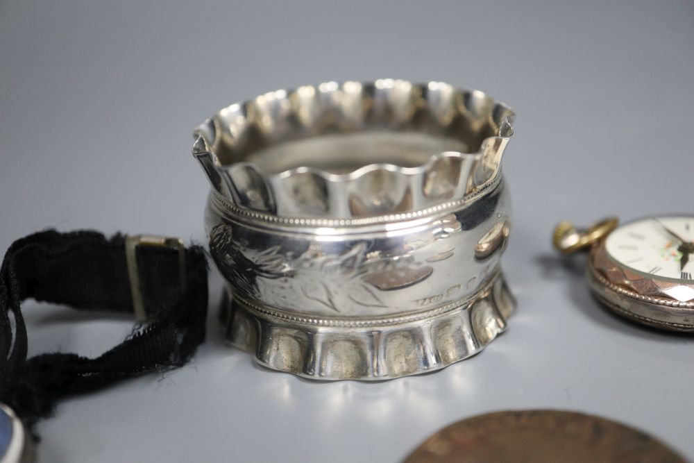 A silver and enamel wrist watch, a silver napkin ring, silver pill box and five assorted worn coins.